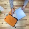 Stor orange laptopväska i jute och bomull vid transport