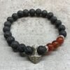 bG9jYWw6Ly9tZWRpYS8xRy9KQy82MFIzMEMxRzZNVDNKQzFHL2M4NGNkMzM4LmpwZWc.jpg Svart armband med lavasten och röda karneolpärlor