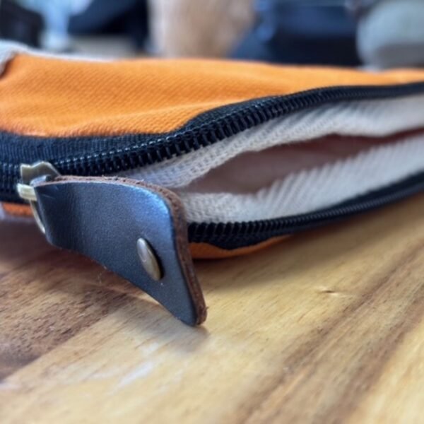 Öppen orange laptopväska med vit insida