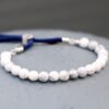 Vitt howlitarmband med silverfärgade detaljer