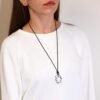 Halsband med bergkristall buret runt halsen