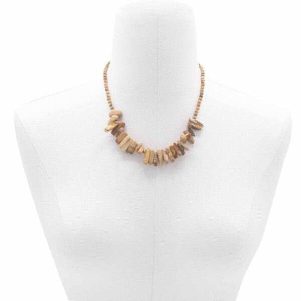 Halsband med beige och bruna stenar mot vit bakgrund