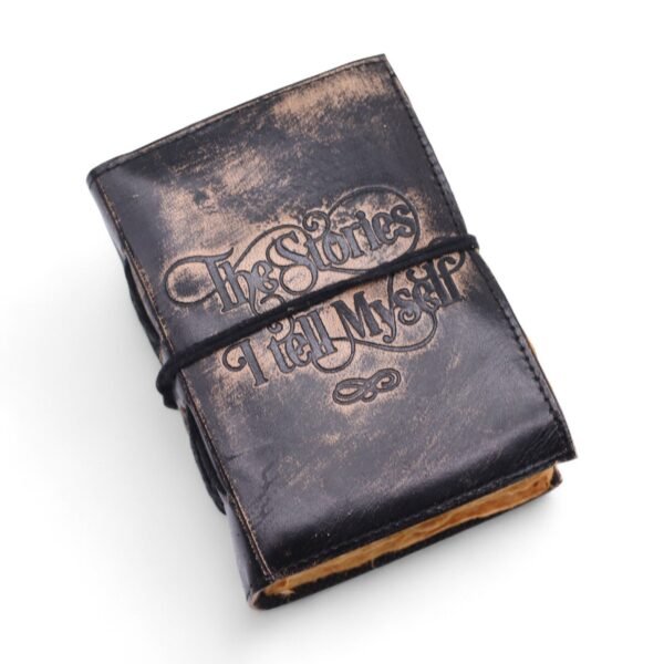 Anteckningsbok i läder med texten The Stories I Tell Myself
