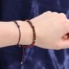 Rött kristallarmband för Väduren på handled